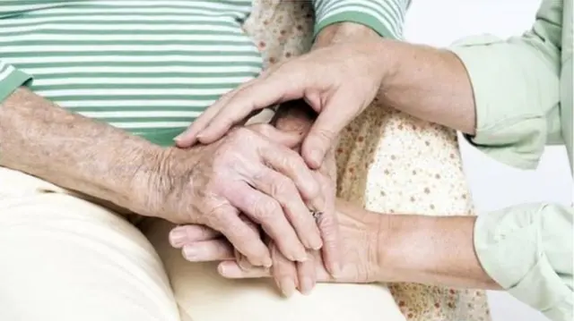 Old couple holding hands