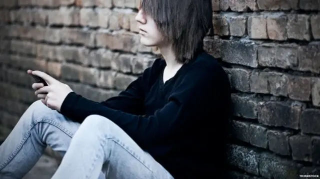 Child leaning against wall