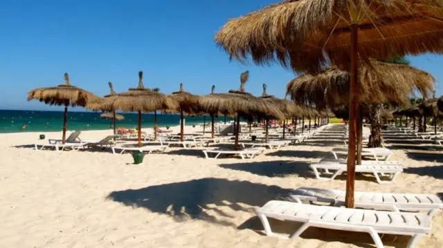 White sandy beach with deckchairs and the Mediterranean in the background