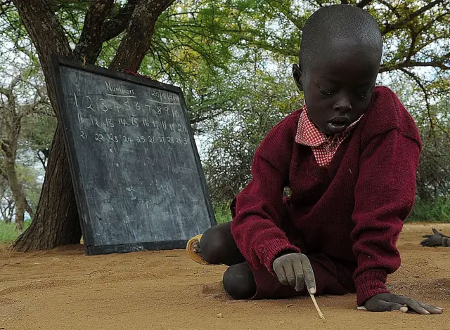 A beginners class pupil scribbles notes on the ground during a lesson at the Oloserian primary school in Kajiado county, some 100 kilometres (60 miles) south of the capital Nairobi, on May 20, 2014