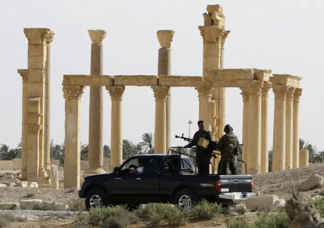 Syrian army troops patrol the ancient city of Palmyra, regained from IS control with the help of Russian airstrikes and special forces in March this year.