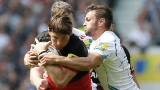 Saracens' Michael Rhodes is tackled by Exeter's Phil Dolman