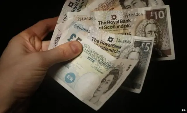 Hand holding Scottish bank notes