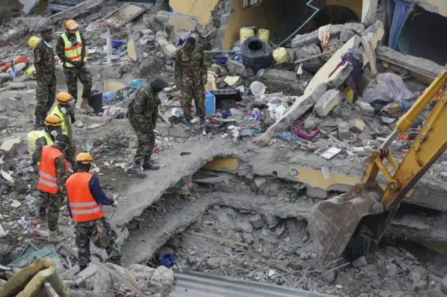 Kenyan soldiers searching through the rubble