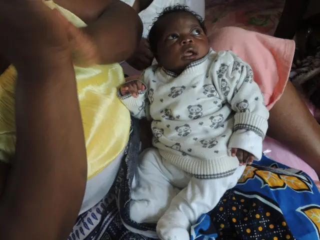 Baby Joy looks up with big brown eyes