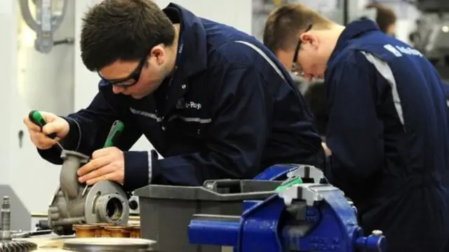 Apprentice engineer working on part