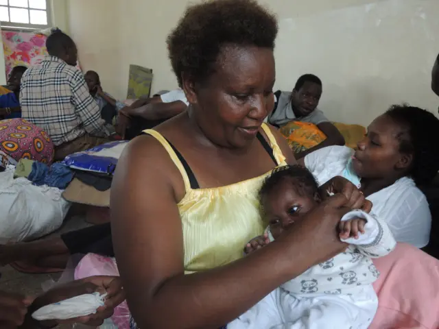 Volunteer cradles baby Joy
