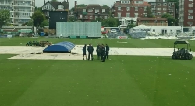 The umpires inspect the pitch at Hove after a rain delay