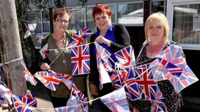 Friends Diane Spencer, Susan Bartrum and Ethel Atkins with flags