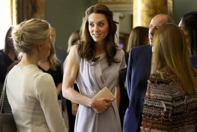 The Duchess of Cambridge speaks with guests during a reception at Spencer House in London,