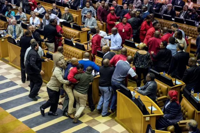 outh African opposition party Economic Freedom Fighters MPs are pushed out of a parliament session during the South African president"s budget speech in Cape Town on May 4, 2016.