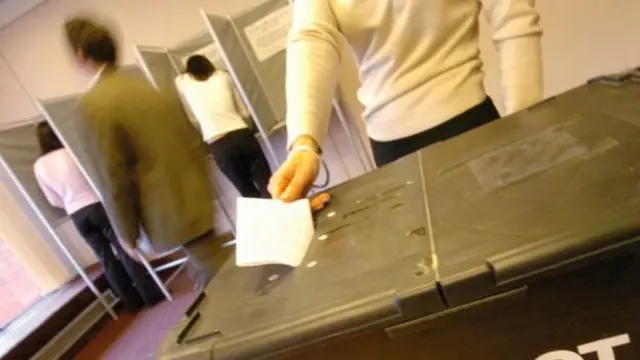 Voter placing vote in box