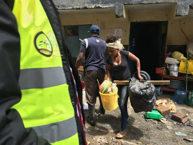 Woman carrying out goods from house