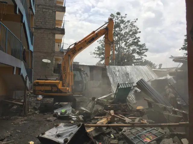 Digger demolishing building