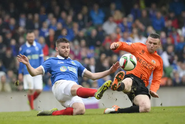 Linfield's Stephen Lowry competes against Andy Kilmartin of Glenavon at Windsor Park