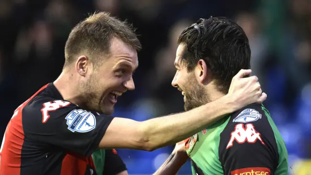 Glentoran's Ciaran Caldwell celebrates with goalscorer Curtis Allen