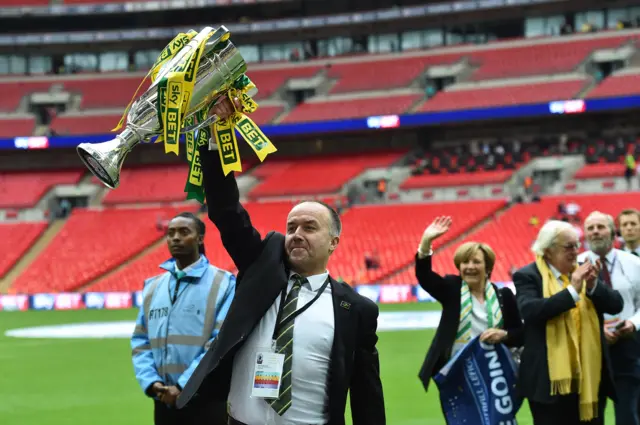 Norwich City chief executive David McNally (L) celebrates with the trophy after the official presentation after Norwich City won the English Championship play off final football match between Middlesbrough and Norwich City at Wembley Stadium in London on May 25, 2015.