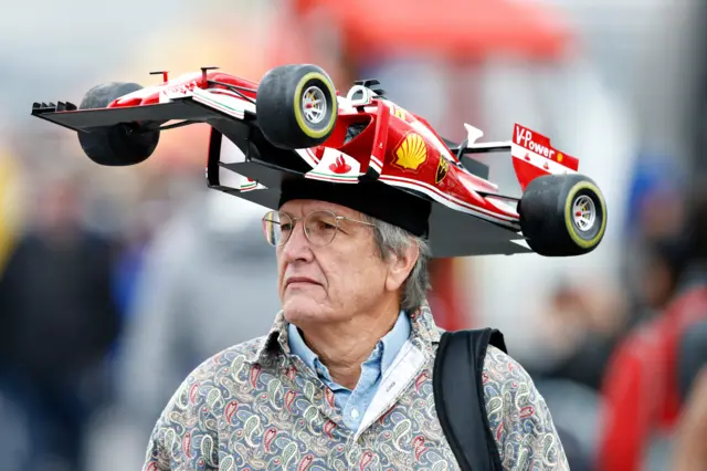 A man wears a Ferrari hat