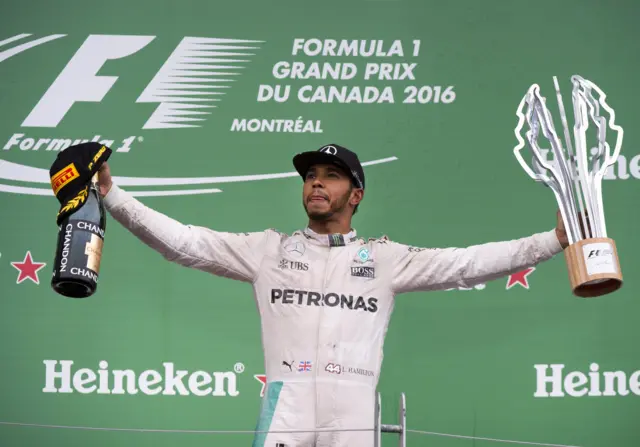 Lewis Hamilton with his winners trophy and champagne