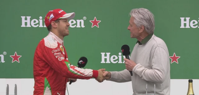 Sebastian Vettel shakes the hand of Michael Douglas