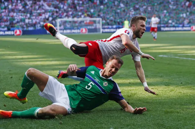 Northern Irish captain Jonny Evans goes in strongly on Jakub Blaszczykowski