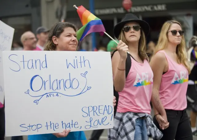 Pride Parade-goers remember the Orlando nightclub victims in Los Angeles, Sunday, June 12, 2016.