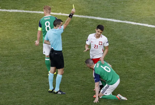 Poland's Bartosz Kapustka receives a yellow card