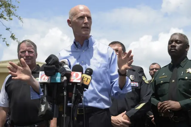 Florida Gov. Rick Scott, center, addresses reporters during a news conference after a shooting involving multiple fatalities at a nightclub in Orlando, Florida