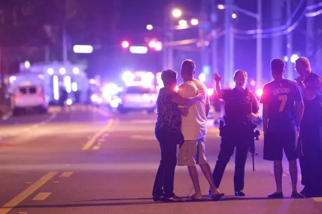 Orlando Police officers direct family members away from a fatal shooting at Pulse Orlando nightclub in Orlando on 12 June 12