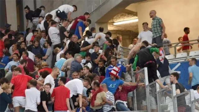 England fans climbing a fence in the ground at Marseille to avoid attack by Russia fans