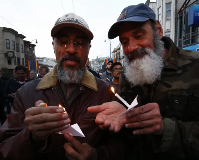 Men at a candlelight vigil in San Francisco