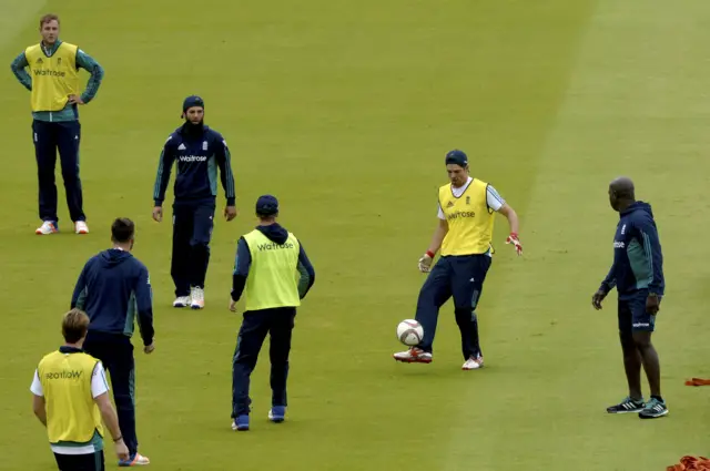 England players keep warm with a football