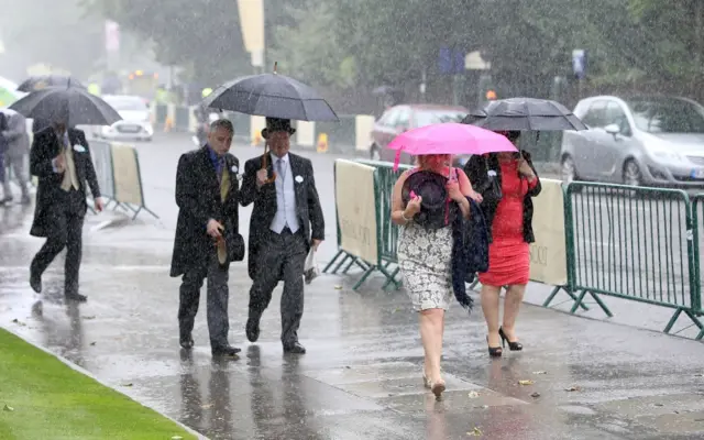 Racegoers arrive at Ascot in the rain