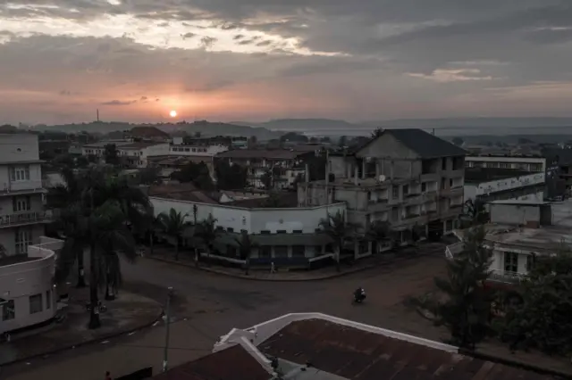 Sun setting behind buildings in Jinja