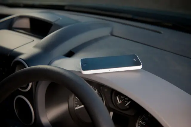 mobile phone on the dashboard of a car