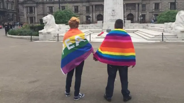 Two vigil-goers in Glasgow were draped in the Rainbow Pride flag