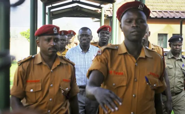 Kizza Besigye, center, is led into of a magistrate's court in the capital Kampala, Uganda Wednesday, May 18, 2016