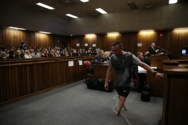 Paralympic gold medalist Oscar Pistorius walks across the courtroom without his prosthetic legs during the third day of the resentencing hearing for the 2013 murder of his girlfriend Reeva Steenkam