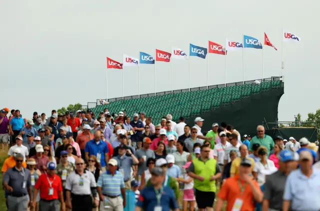 Fans walk the course following suspended play