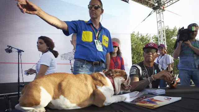 Lewis Hamilton and his dog sign autographs