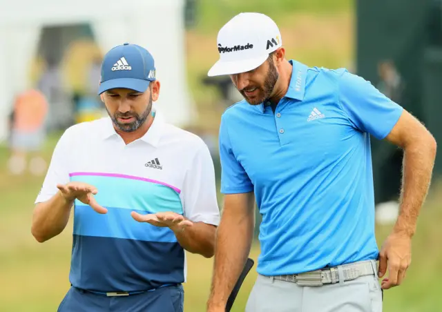 Dustin Johnson of the United States talks to Sergio Garcia