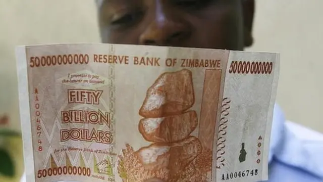 A Zimbabwean looks at a $50bn Zimbabwean issued on 13 January 2009