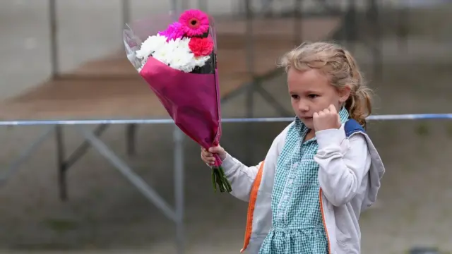 A schoolgirl carrying a bunch of flowers