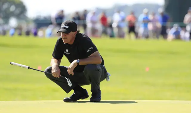 Phil Mickelson lines up a putt