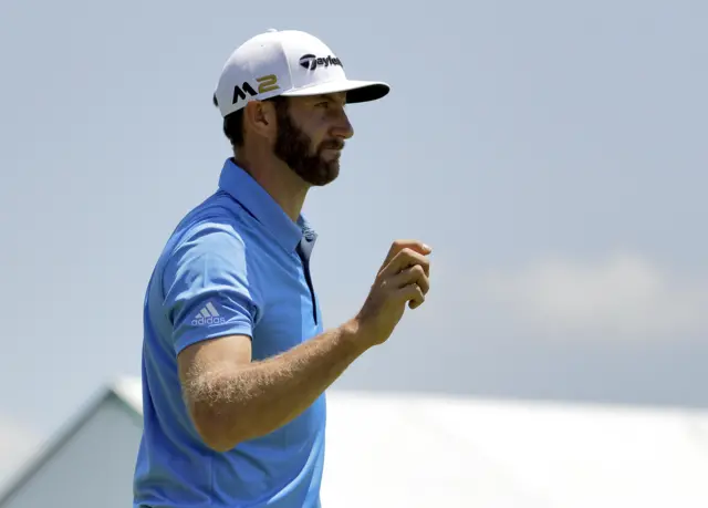 Dustin Johnson waves on the 16th green