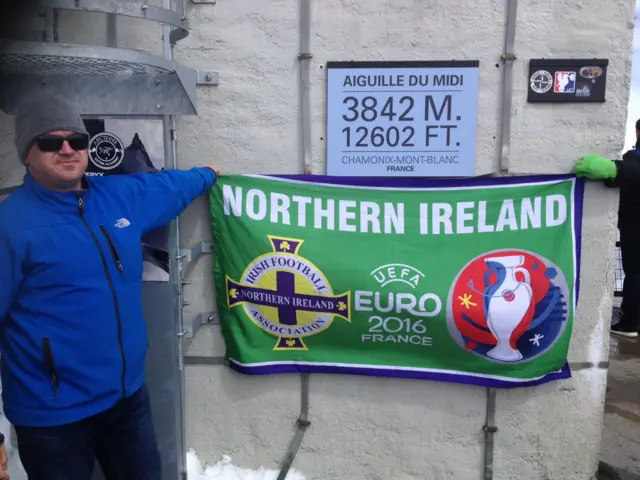 A Northern Ireland fan holds a flag at Mont Blanc