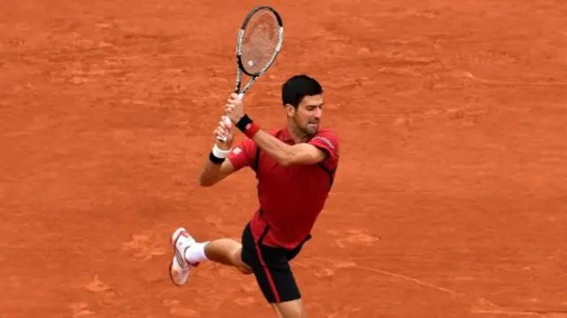 Novak Djokovic hits a backhand