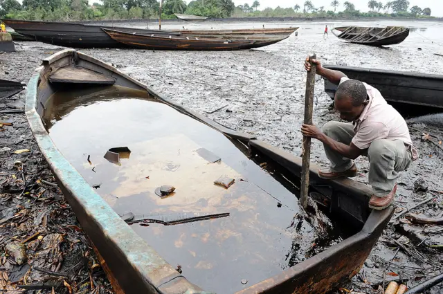 Man tries to separate out crude oil from water in his boat