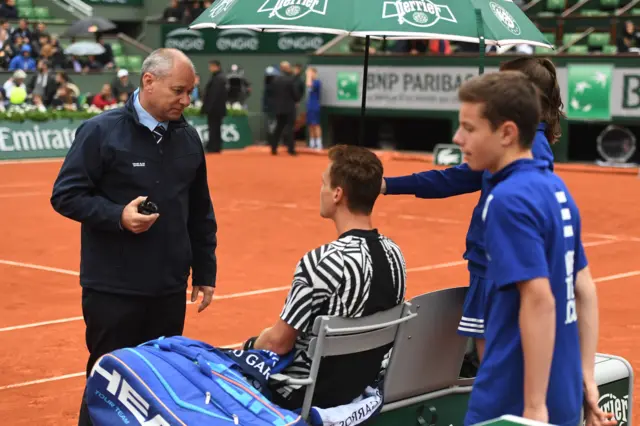 Tomas Berdych consults with the match officials