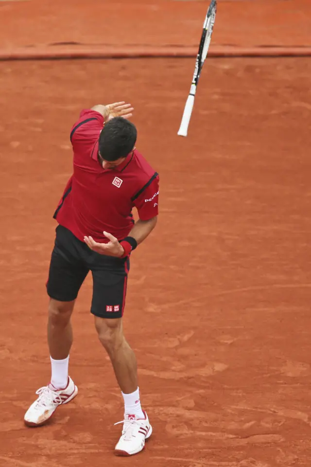 Novak Djokovic throws his racket